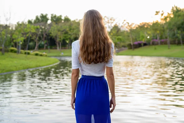 Hermosa mujer con el pelo largo de pie y mirando panorámica vi —  Fotos de Stock