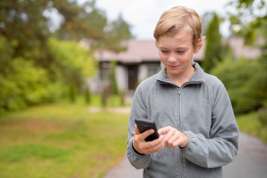Genç mutlu yakışıklı çocuk telefon evde açık havada kullanma