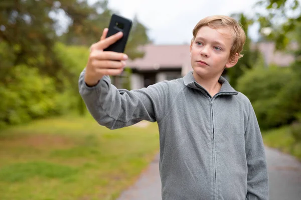 Νεαρή ξανθιά Ωραίος Boy λήψη Selfie στο σπίτι σε εξωτερικούς χώρους — Φωτογραφία Αρχείου