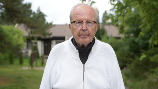 Heureux homme âgé avec des lunettes de vue souriant à la maison en plein air — Video