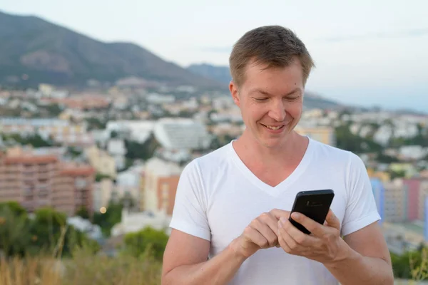 Νέοι ευτυχισμένη τουριστικά άνθρωπος χρησιμοποιώντας το τηλέφωνο στην κορυφή του λόφου — Φωτογραφία Αρχείου