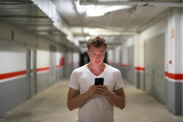 Молодий красенем використання телефону по коридору — стокове фото