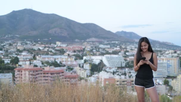 Młody piękny turysta Asian kobieta uśmiechając się podczas biorąc Selfie na wzgórzu — Wideo stockowe