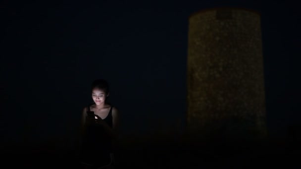 Giovane felice asiatico turista donna utilizzando telefono su il collina a notte — Video Stock