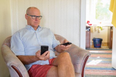 Komuta sizde evde televizyon izlerken telefon tutarak