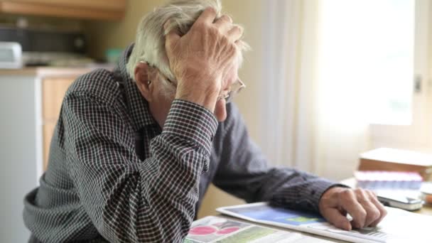 Hombre mayor pensando mientras lee el periódico junto a la ventana — Vídeo de stock