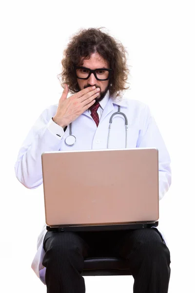 Студійний знімок красивого лікаря за допомогою ноутбука, який виглядає шокованим — стокове фото