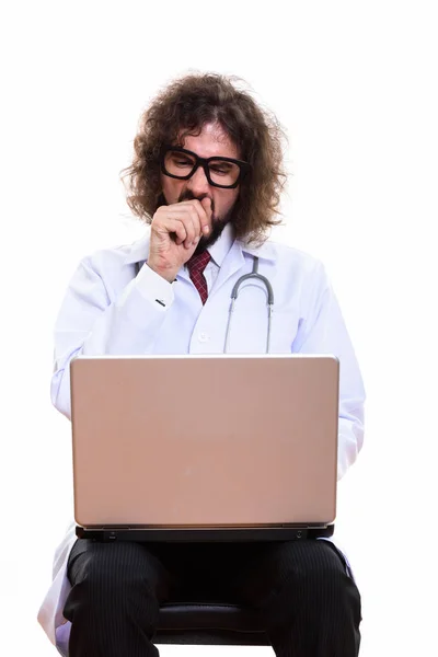 Studio shot of tired man doctor using laptop while yawning — Stock Photo, Image