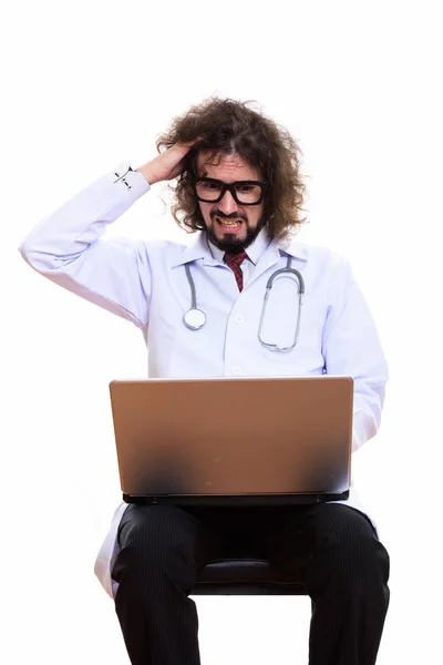 Studio colpo di stressato uomo medico utilizzando computer portatile con mano sul suo — Foto Stock
