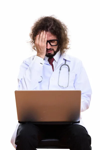 Студийный снимок стрессового врача с ноутбука, прикрывающего лицо — стоковое фото