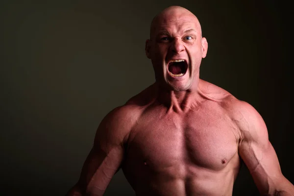 Bald muscular man shirtless against colored background — Stock Photo, Image