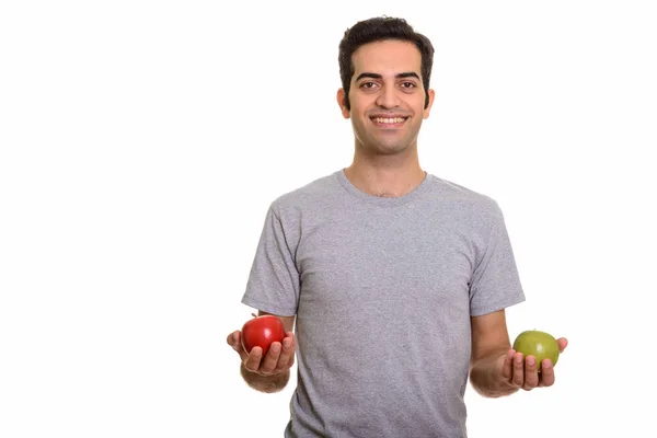 Joven hombre persa feliz sosteniendo manzana roja y verde listo para gy — Foto de Stock