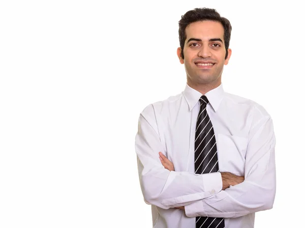 Young happy Persian businessman smiling with arms crossed — Stock Photo, Image