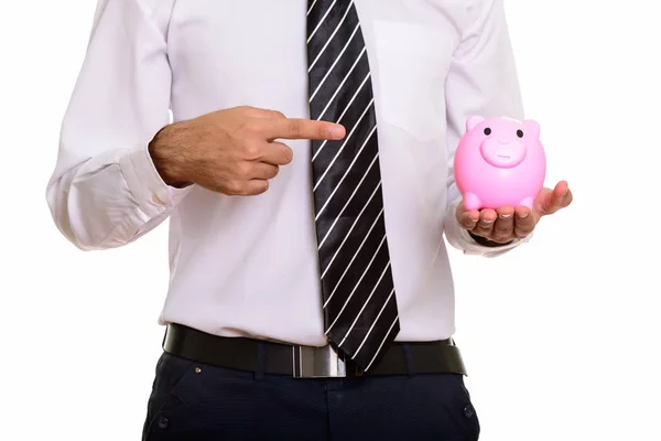Young businessman holding piggy bank and pointing finger — Stock Photo, Image