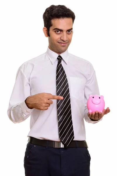 Young Persian businessman holding piggy bank and pointing finger — Stock Photo, Image