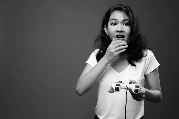 Mulher asiática bonita jogando jogos e segurando controlador de jogo — Fotografia de Stock