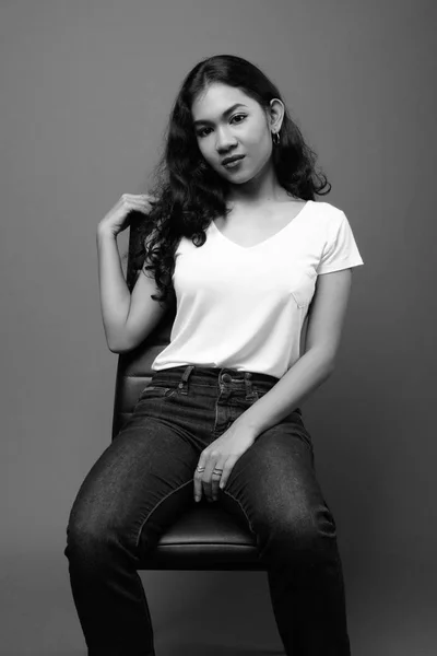 Giovane bella donna asiatica seduta studio girato in bianco e nero — Foto Stock