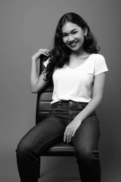Ung Vacker asiatisk kvinna sittande studio skott i svart och vitt — Stockfoto