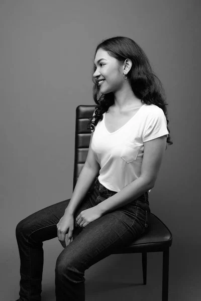 Jovem bela mulher asiática sentado estúdio filmado em preto e branco — Fotografia de Stock
