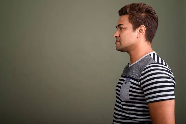 Индийский мужчина в полосатой рубашке на цветном фоне — стоковое фото