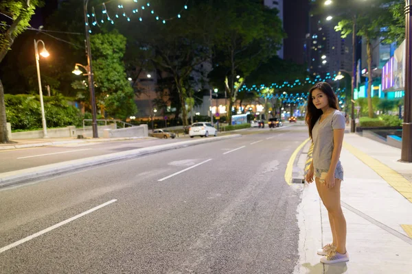 Young beautiful Asian woman wandering in the city streets at nig — Stock Photo, Image