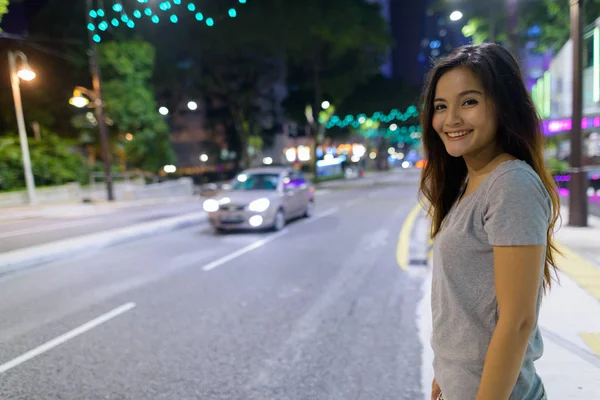 Jonge mooie Aziatische vrouw dwalen in de straten van de stad op nig — Stockfoto