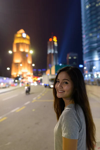 Jonge mooie Aziatische vrouw dwalen in de straten van de stad op nig — Stockfoto