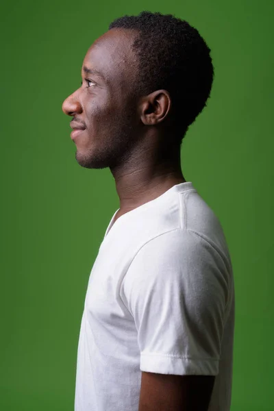 Profil pohled portrét mladíka africké zelené pozadí — Stock fotografie