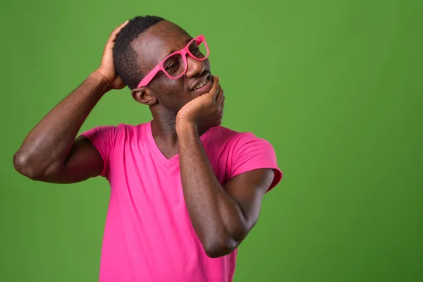 Genç Afrikalı adamın yeşil arka planda çekilmiş bir fotoğrafı.