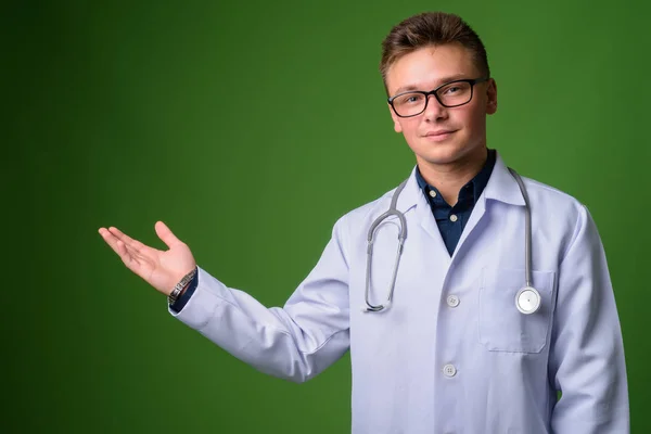 Jonge knappe man arts tegen groene achtergrond — Stockfoto