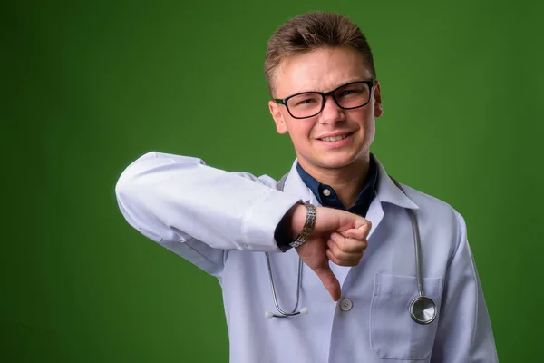 Jonge knappe man arts tegen groene achtergrond — Stockfoto