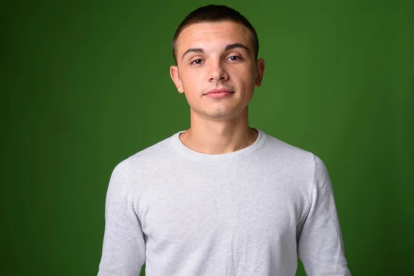 Estúdio tiro de jovem bonito homem contra fundo verde — Fotografia de Stock