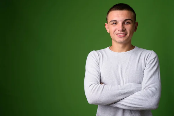 Studioaufnahme eines jungen gutaussehenden Mannes vor grünem Hintergrund — Stockfoto