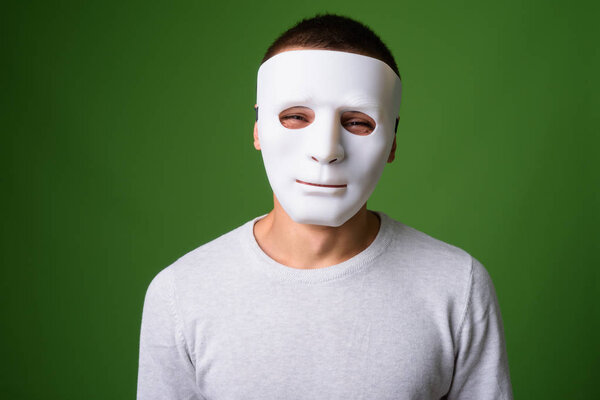 Studio shot of young handsome man against green background