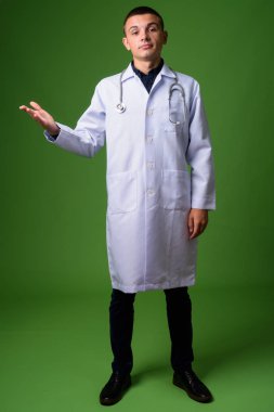 Genç yakışıklı adam doktor yeşil bir arka plana dayanır
