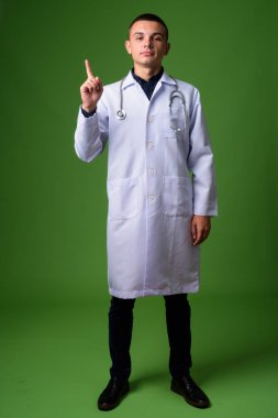 Genç yakışıklı adam doktor yeşil bir arka plana dayanır