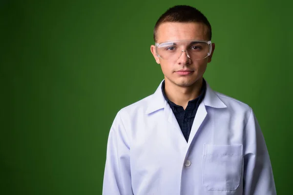 Молодой красивый доктор в защитных очках против гра — стоковое фото