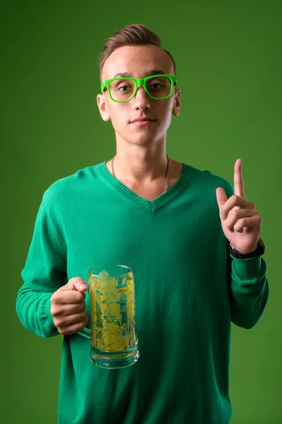 Студийный снимок молодого красивого мужчины на зеленом фоне — стоковое фото