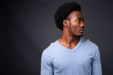 Gri arka planda yakışıklı Afrikalı genç adam