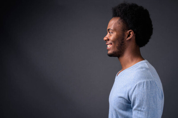 Studio shot of young handsome African man against gray background
