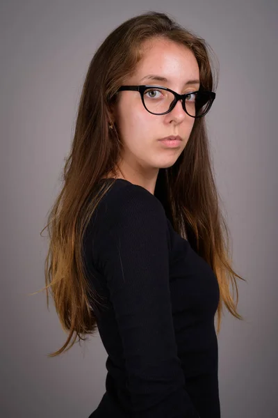 Retrato de jovem bela mulher contra fundo cinza — Fotografia de Stock