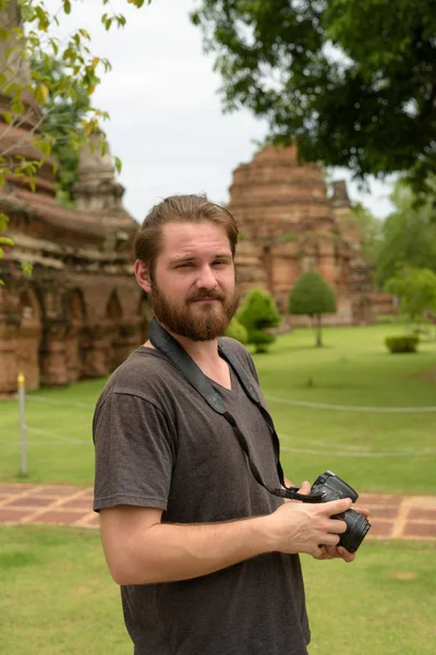 Young bearded tourist man having vacation in Ayutthaya, Thailand