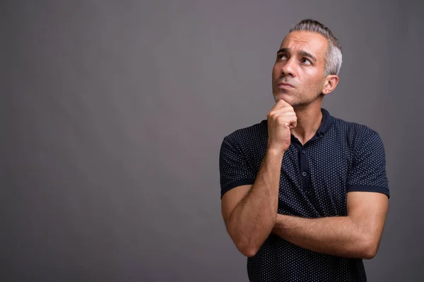 Handsome Persian man with gray hair thinking and looking up — Stock Photo, Image