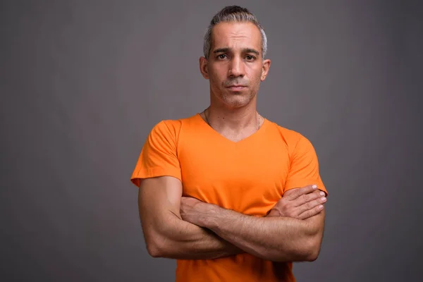 Handsome Persian man with gray hair wearing orange t-shirt — Stock Photo, Image