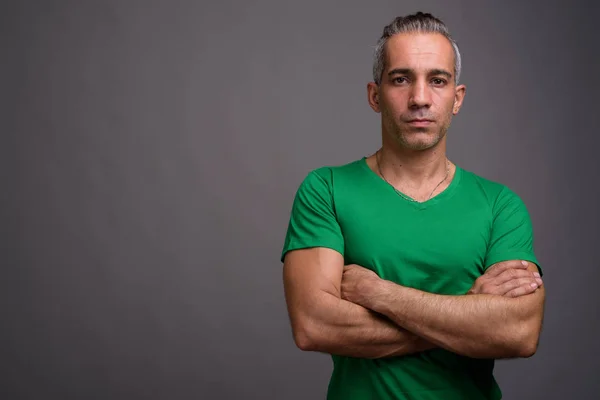 Hombre persa guapo con pelo gris vistiendo camiseta verde —  Fotos de Stock