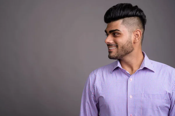 Joven guapo empresario indio contra fondo gris —  Fotos de Stock
