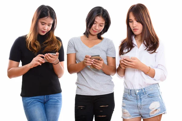 Estúdio tiro de três jovens asiático mulher amigos usando celular phon — Fotografia de Stock