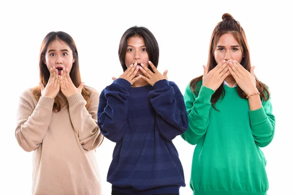Studio schot van drie jonge Aziatische vrouw vrienden die betrekking hebben op mond wh — Stockfoto