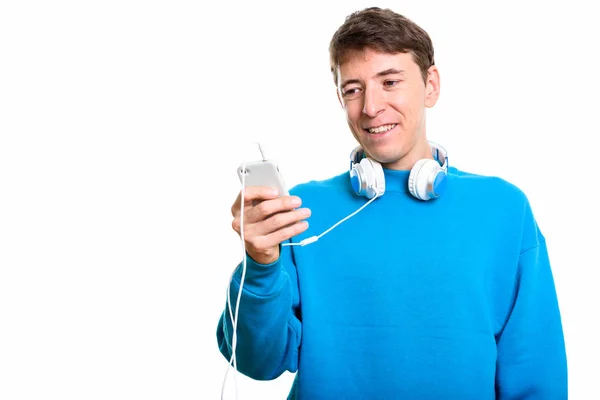 Hombre feliz sonriendo mientras usa auriculares alrededor del cuello y usando —  Fotos de Stock