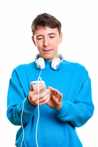 Estúdio tiro de homem usando fones de ouvido em torno do pescoço ao usar mo — Fotografia de Stock